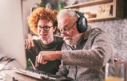 Junger Mann und alter Mann sitzen am Computer